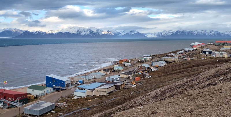 Et lite inuittsamfunn ved kysten i Arktisk Canada, med fjell i bakgrunnen